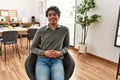 Young hispanic businessman smiling happy sitting on chair at the office Royalty Free Stock Photo