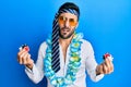 Young hispanic businessman wearing party funny style holding casino chips clueless and confused expression Royalty Free Stock Photo