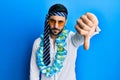 Young hispanic businessman wearing party funny style with tie on head looking unhappy and angry showing rejection and negative