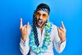 Young hispanic businessman wearing party funny style with tie on head shouting with crazy expression doing rock symbol with hands Royalty Free Stock Photo