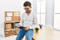 Young hispanic businessman writing on  clipboard sitting on the table at the office Royalty Free Stock Photo