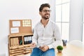 Young hispanic businessman writing on  clipboard sitting on the table at the office Royalty Free Stock Photo