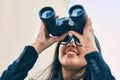 Young hispanic businesswoman looking for new opportunity using binoculars at the city Royalty Free Stock Photo