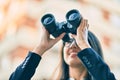 Young hispanic businesswoman looking for new opportunity using binoculars at the city Royalty Free Stock Photo