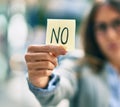 Young hispanic businesswoman with serious expression holding reminder with no message at the city