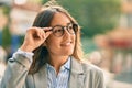 Young hispanic businesswoman smiling happy touching her glasses at the city Royalty Free Stock Photo