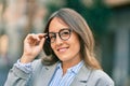 Young hispanic businesswoman smiling happy touching her glasses at the city Royalty Free Stock Photo