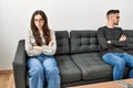 Young hispanic couple angry sitting on the sofa in silence at home