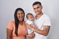 Young hispanic couple with baby standing together over isolated background winking looking at the camera with sexy expression, Royalty Free Stock Photo