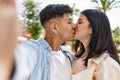 Young hispanic couple of boyfriend and girlfriend together outdoors on a sunny day, smiling in love taking a selfie picture Royalty Free Stock Photo