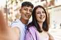 Young hispanic couple of boyfriend and girlfriend together outdoors on a sunny day, smiling in love taking a selfie picture Royalty Free Stock Photo