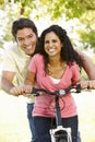 Young Hispanic Couple Cycling In Park Royalty Free Stock Photo