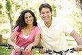 Young Hispanic Couple Cycling In Park