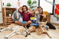 Young hispanic couple doing laundry with dogs doing frame using hands palms and fingers, camera perspective Royalty Free Stock Photo