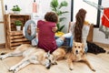 Young hispanic couple doing laundry with dogs hugging oneself happy and positive from backwards