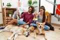 Young hispanic couple doing laundry with dogs looking proud, smiling doing thumbs up gesture to the side