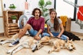 Young hispanic couple doing laundry with dogs in shock face, looking skeptical and sarcastic, surprised with open mouth Royalty Free Stock Photo