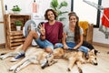 Young hispanic couple doing laundry with dogs showing and pointing up with fingers number four while smiling confident and happy