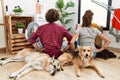 Young hispanic couple doing laundry with dogs standing backwards looking away with arms on body Royalty Free Stock Photo