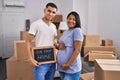 Young hispanic couple expecting a baby moving to a new home smiling with a happy and cool smile on face Royalty Free Stock Photo