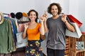 Young hispanic couple holding shopping bags at retail shop smiling amazed and surprised and pointing up with fingers and raised Royalty Free Stock Photo