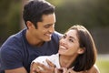 Young Hispanic couple looking at each other smiling, close up