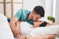 Young hispanic couple lying on bed hugging each other and kissing at bedroom Royalty Free Stock Photo
