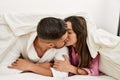 Young hispanic couple lying in bed kissing at home Royalty Free Stock Photo