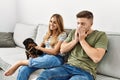 Young hispanic couple sitting on the sofa with dog at home Royalty Free Stock Photo
