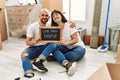 Young hispanic couple smiling happy holding our new home blackboard at new home Royalty Free Stock Photo