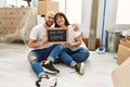 Young hispanic couple smiling happy holding our new home blackboard at new home Royalty Free Stock Photo