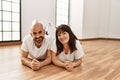 Young hispanic couple smiling happy lying on the floor at empty new home Royalty Free Stock Photo