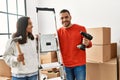 Young hispanic couple smiling happy repairing new home