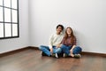 Young hispanic couple smiling happy sitting on the floor at empty new home Royalty Free Stock Photo