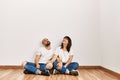 Young hispanic couple smiling happy sitting on the floor at empty new home Royalty Free Stock Photo