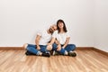 Young hispanic couple smiling happy sitting on the floor at empty new home Royalty Free Stock Photo