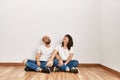 Young hispanic couple smiling happy sitting on the floor at empty new home Royalty Free Stock Photo