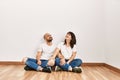 Young hispanic couple smiling happy sitting on the floor at empty new home Royalty Free Stock Photo