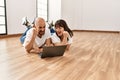 Young hispanic couple smiling happy using laptop at empty new home Royalty Free Stock Photo