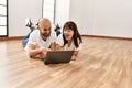 Young hispanic couple smiling happy using laptop at empty new home Royalty Free Stock Photo