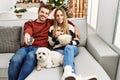 Young hispanic couple smiling happy watching movie sitting on the sofa with dog at home Royalty Free Stock Photo