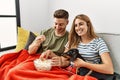 Young hispanic couple smiling happy watching movie sitting on the sofa with dog at home Royalty Free Stock Photo