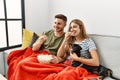 Young hispanic couple smiling happy watching movie sitting on the sofa with dog at home Royalty Free Stock Photo