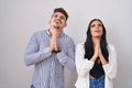 Young hispanic couple standing over white background begging and praying with hands together with hope expression on face very Royalty Free Stock Photo