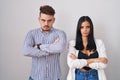 Young hispanic couple standing over white background skeptic and nervous, disapproving expression on face with crossed arms Royalty Free Stock Photo