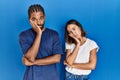Young hispanic couple standing together thinking looking tired and bored with depression problems with crossed arms Royalty Free Stock Photo