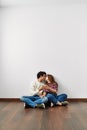 Young hispanic couple toasting with champagne sitting on the floor at empty new home Royalty Free Stock Photo