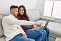 Young hispanic couple using laptop sitting on the sofa at home Royalty Free Stock Photo