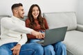 Young hispanic couple using laptop sitting on the sofa at home Royalty Free Stock Photo