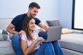 Young hispanic couple using laptop sitting on sofa at home Royalty Free Stock Photo